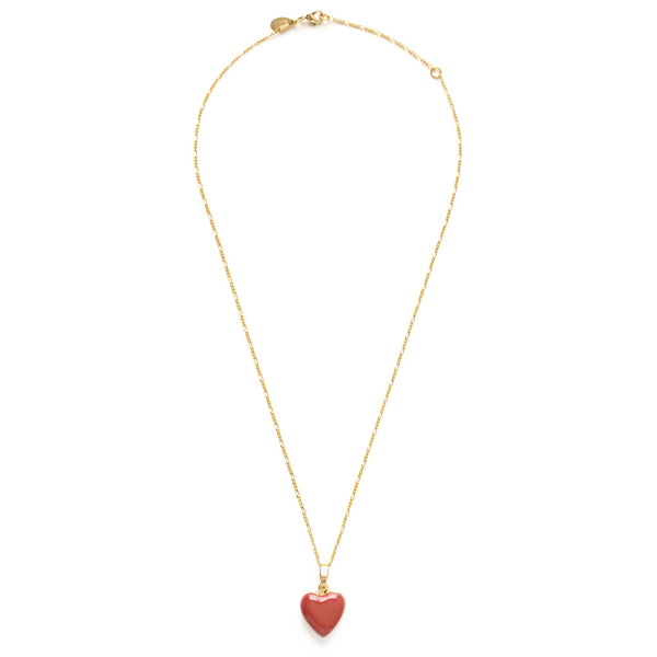 Gold necklace with a red heart pendant on a white background