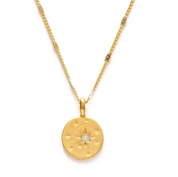 Gold necklace with a round pendant on a white background