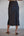 Person wearing a dark blue skirt with a plain background