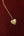 Gold heart-shaped pendant necklace with 'Puerto Rico' engraving on a red background