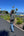 Person walking on a path with palm trees and a clear blue sky in the background