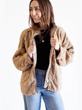Woman wearing a beige jacket on a white background