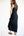 Woman wearing a black sleeveless dress against a white background