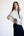 Woman wearing a white fleece pullover with black trim against a white background