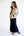 Woman wearing a beige and black jacket with a navy skirt on a white background
