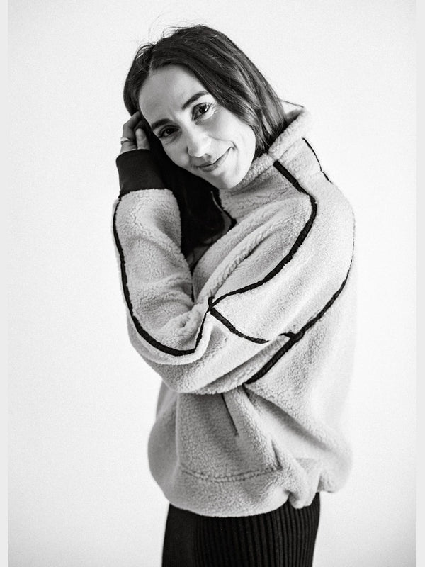 Black and white photo of a person wearing a textured sweater.