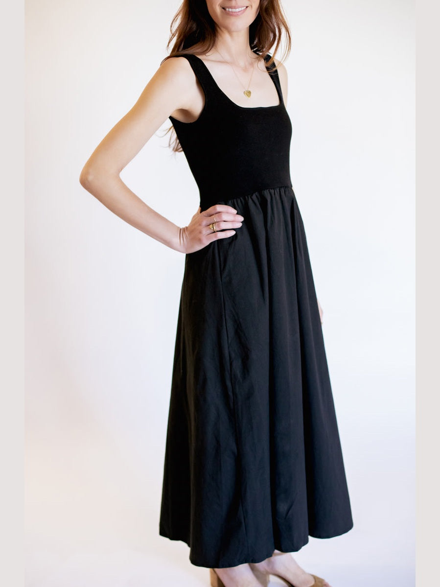 Woman wearing a black sleeveless dress against a white background