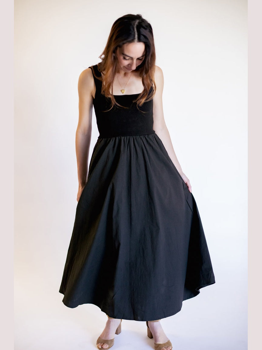 Woman wearing a black sleeveless dress against a white background