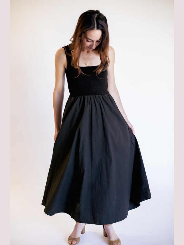 Woman wearing a black sleeveless dress against a white background