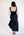 Woman wearing a black dress with an open back against a white background