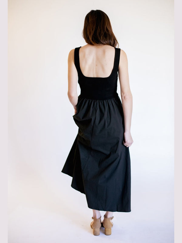 Woman wearing a black dress with an open back against a white background