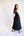 Woman wearing a black sleeveless dress against a white background