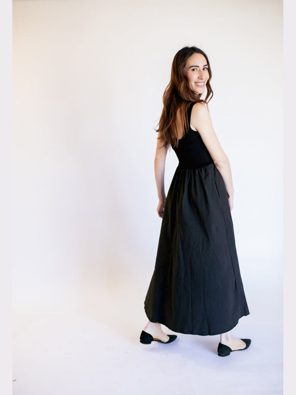 Woman wearing a black sleeveless dress against a white background