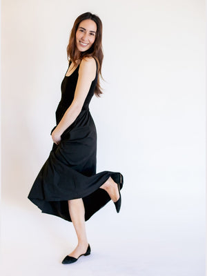 Woman wearing a black sleeveless dress on a white background