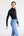 Woman wearing a black long-sleeve top and blue jeans on a white background