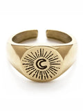 Gold ring with engraved design on a white background