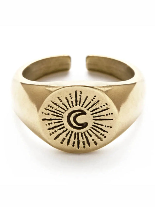 Gold ring with engraved design on a white background