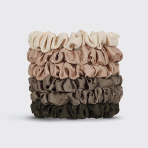 Stack of brown and beige scrunchies on a light gray background