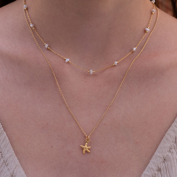 woman wearing tiny starfish necklace