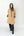 woman in tan trench coat and grey jeans