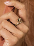 Close-up of a hand wearing a gold ring with a snake design.